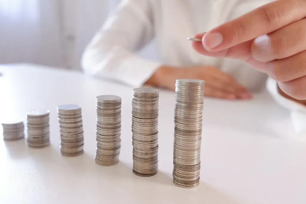Imagen de un hombre apilando monedas